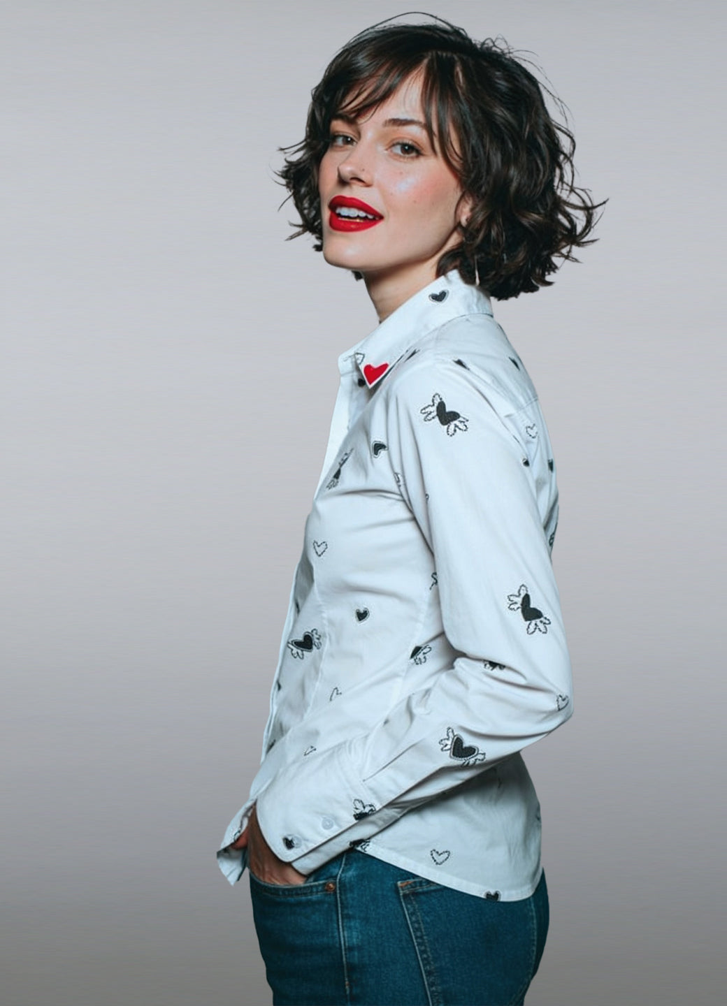 Camisa de manga larga en popelina de algodón blanco. Un diseño que combina comodidad y vanguardia gracias a su estampado de micro-corazones negros y su distintivo aplique rojo en el cuello.